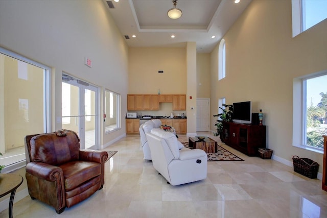 living room featuring baseboards, visible vents, a towering ceiling, a tray ceiling, and recessed lighting