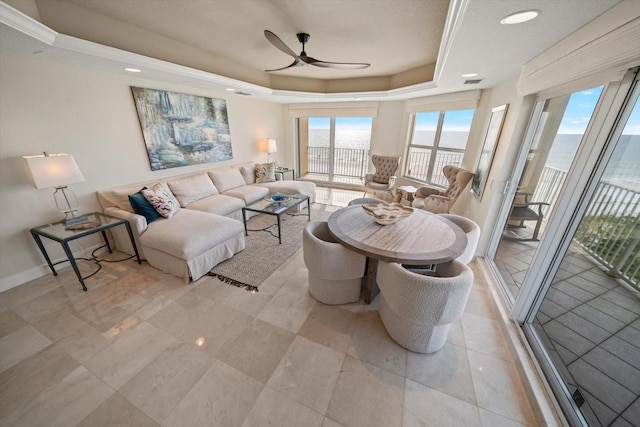 living room featuring a ceiling fan, a raised ceiling, visible vents, and baseboards