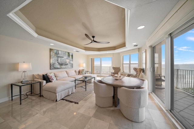 interior space with visible vents, a raised ceiling, and a ceiling fan