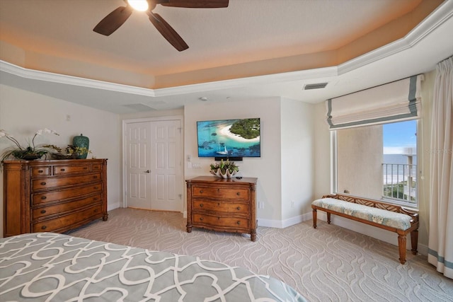 bedroom with light carpet, baseboards, visible vents, a raised ceiling, and ceiling fan