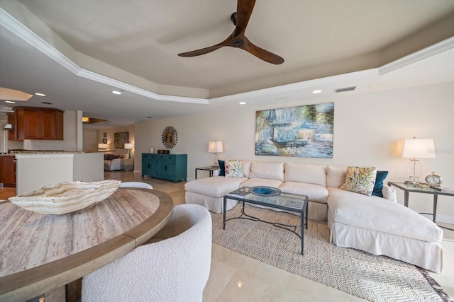 living area with a ceiling fan, a tray ceiling, visible vents, and recessed lighting