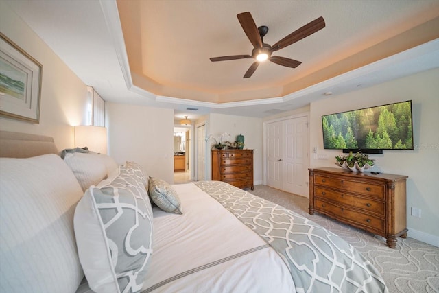 bedroom featuring ceiling fan, baseboards, a closet, carpet, and a raised ceiling