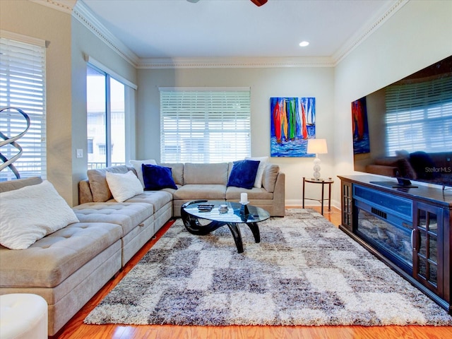 living room with ornamental molding, hardwood / wood-style flooring, and ceiling fan