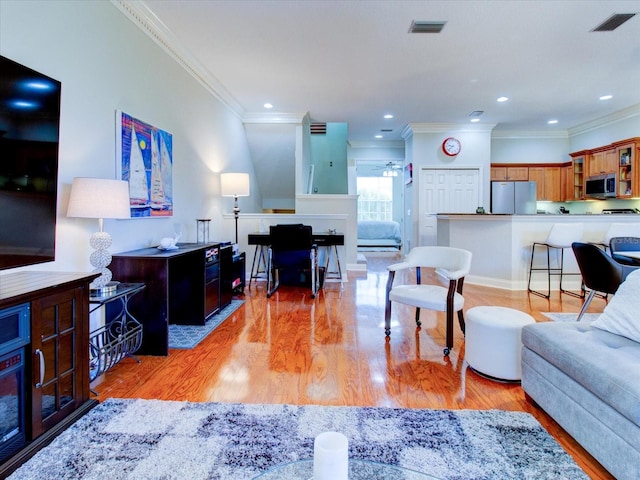 living room featuring crown molding, a fireplace, and wood-type flooring