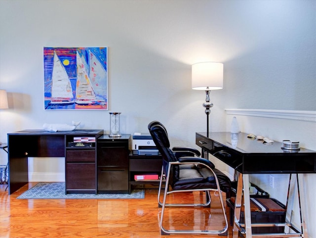 home office with light hardwood / wood-style flooring