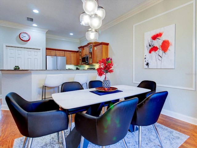 dining room with crown molding and wood-type flooring