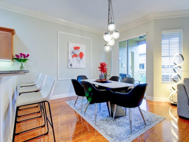 dining space featuring crown molding, a chandelier, and light hardwood / wood-style floors