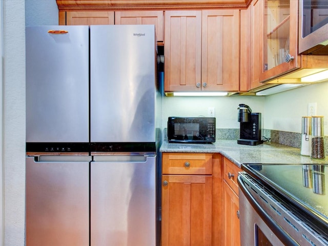 kitchen featuring light stone counters and appliances with stainless steel finishes