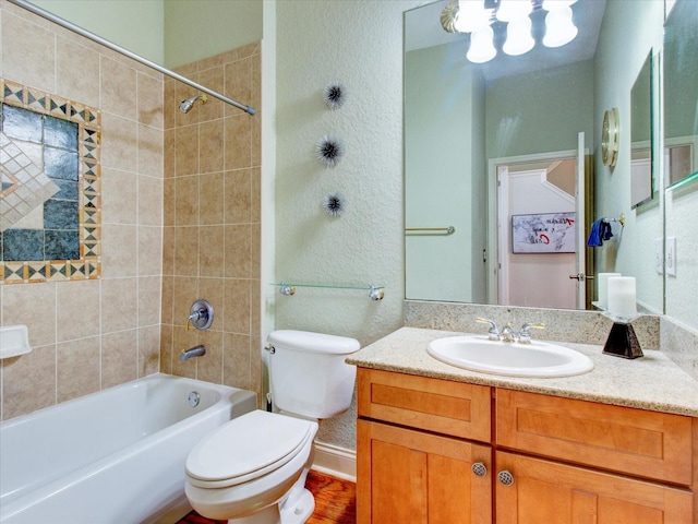 full bathroom featuring wood-type flooring, toilet, tiled shower / bath combo, and vanity