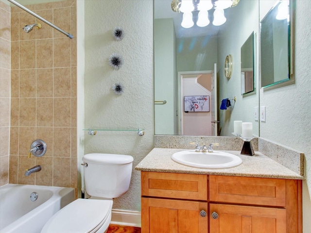 full bathroom featuring tiled shower / bath combo, vanity, and toilet