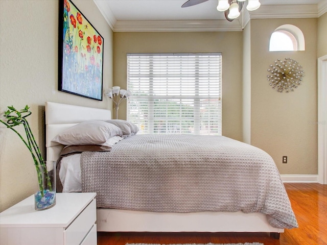 bedroom featuring crown molding, wood-type flooring, and ceiling fan