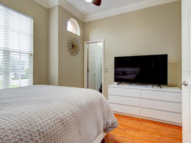 bedroom with light wood-type flooring, crown molding, and ceiling fan