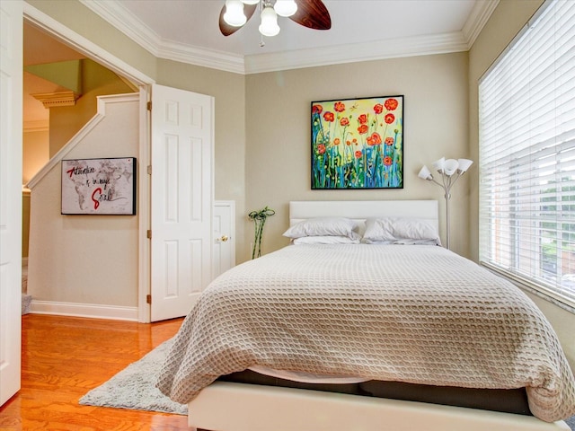 bedroom with crown molding, hardwood / wood-style flooring, and ceiling fan