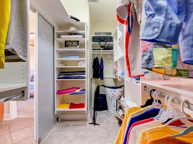 walk in closet with light colored carpet