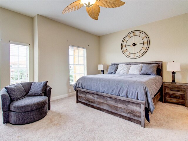 bedroom featuring light carpet, multiple windows, and ceiling fan