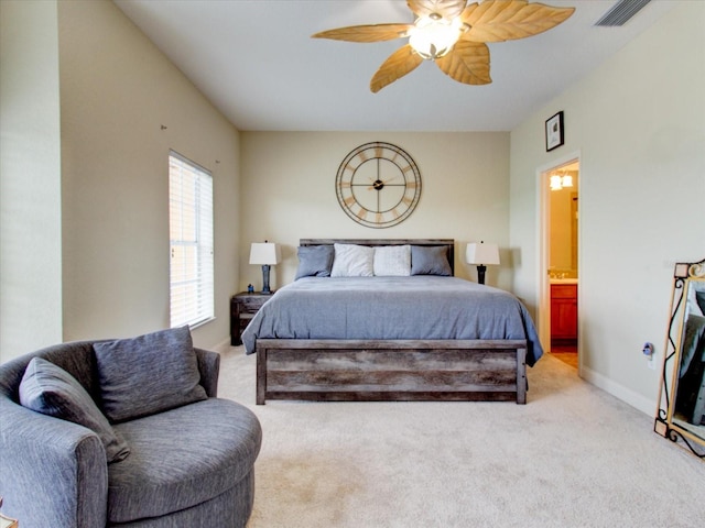 bedroom featuring ceiling fan, light carpet, and ensuite bath