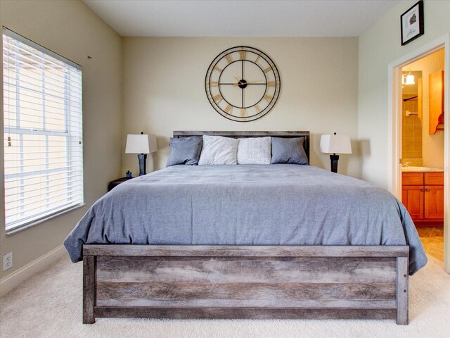 carpeted bedroom with multiple windows and ensuite bath