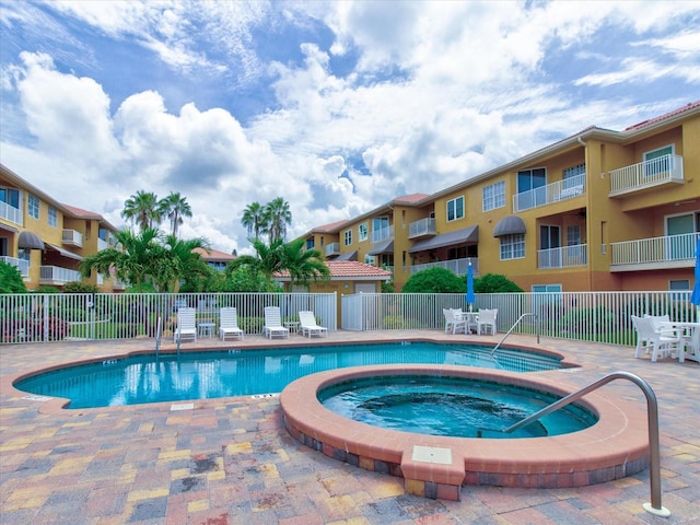 view of swimming pool featuring a hot tub and a patio area