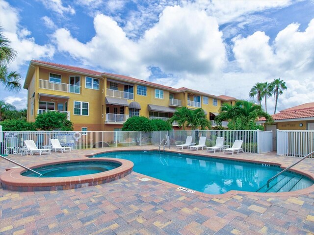 view of swimming pool featuring a community hot tub and a patio area