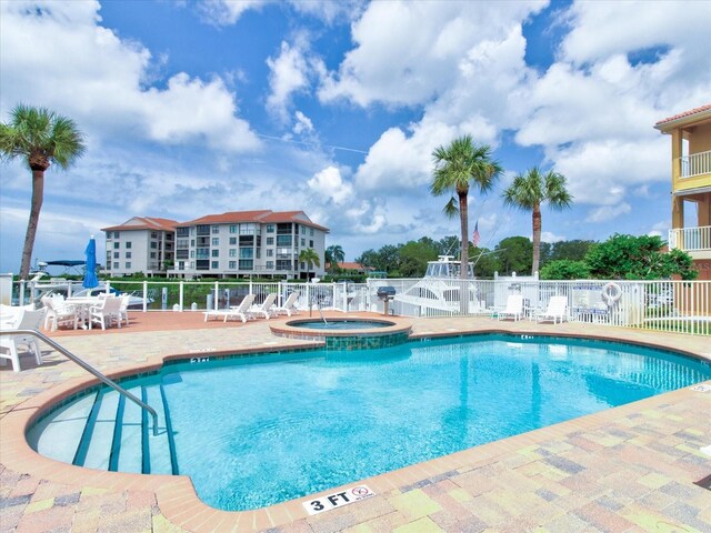 view of swimming pool with a patio and a hot tub