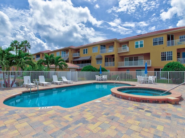 view of swimming pool featuring a community hot tub and a patio