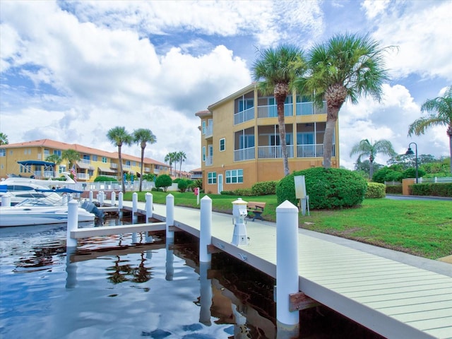 dock area featuring a water view and a lawn