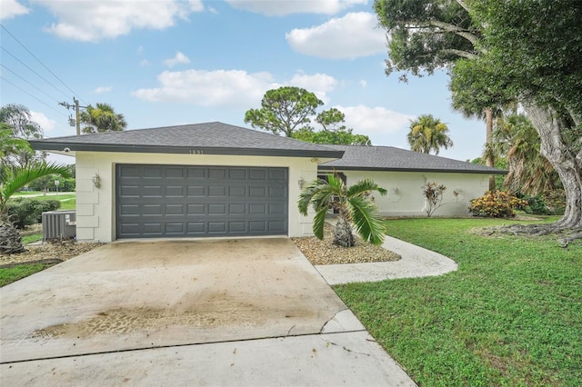 ranch-style home featuring a garage, a front yard, and central AC unit