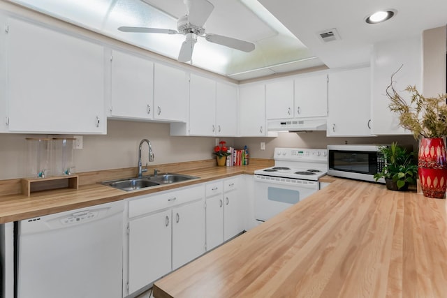 kitchen with white appliances, a sink, under cabinet range hood, wood counters, and white cabinetry