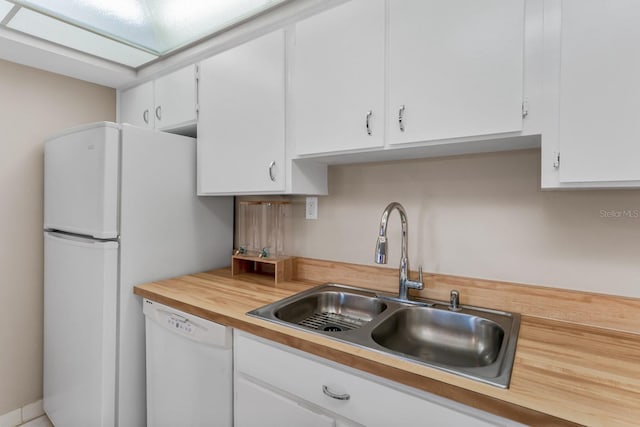 kitchen with a sink, dishwasher, and white cabinets