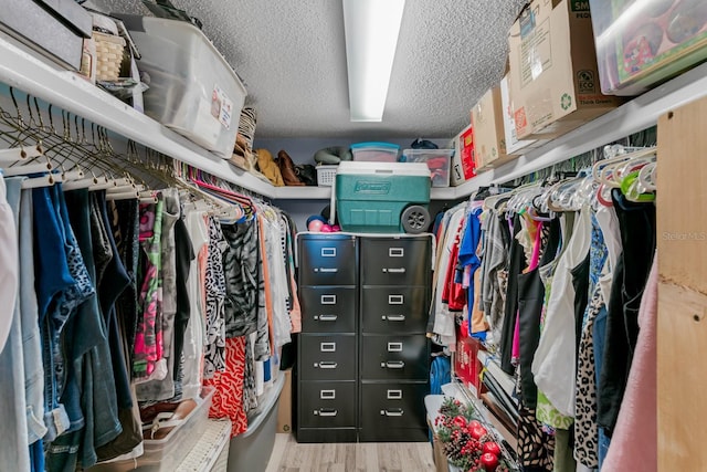 walk in closet with wood finished floors