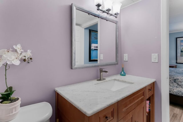 ensuite bathroom with toilet, ensuite bath, vanity, and wood finished floors