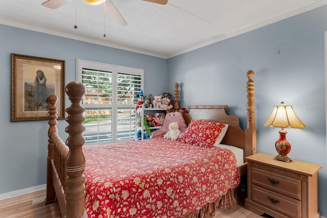 bedroom with ceiling fan, baseboards, wood finished floors, and crown molding