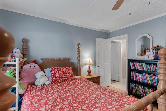 bedroom featuring tile patterned flooring, a textured ceiling, a ceiling fan, and ornamental molding