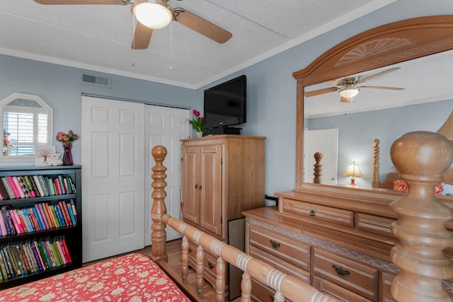 bedroom featuring a textured ceiling, visible vents, a closet, and ornamental molding