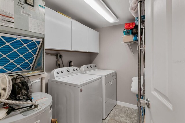 washroom with washer and dryer, baseboards, and cabinet space