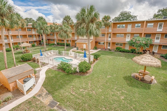 surrounding community with a lawn, a pool, and fence