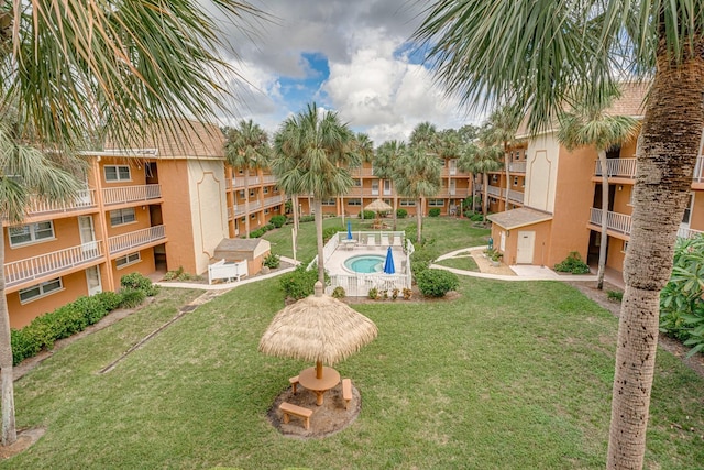 view of home's community with a swimming pool and a yard