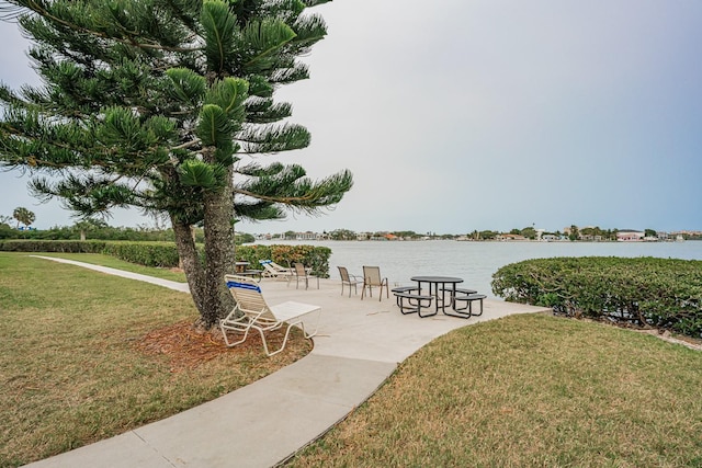 view of community with a yard and a water view