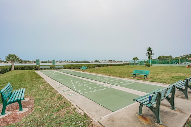 view of community with shuffleboard and a yard