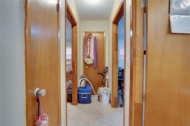 hall featuring a textured ceiling