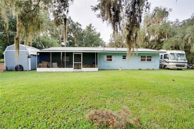 back of property featuring a lawn and a sunroom