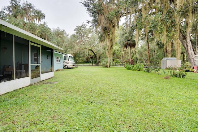 view of yard featuring a storage unit and a sunroom