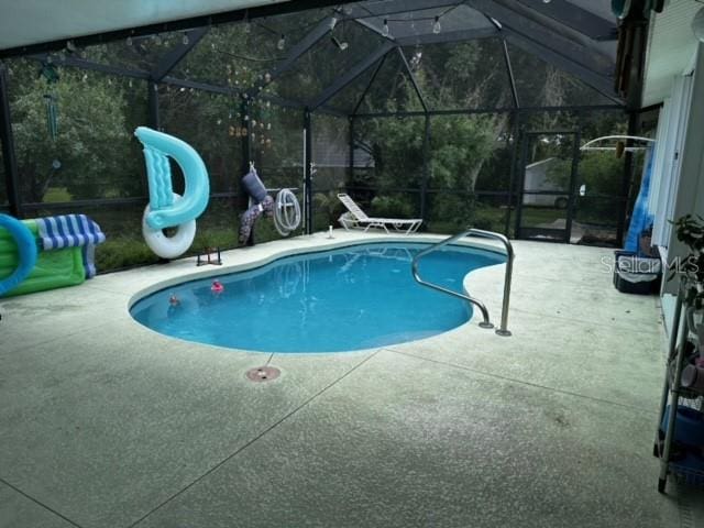 view of pool with a patio and a lanai