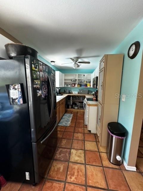 kitchen featuring ceiling fan, black refrigerator, electric stove, and tile patterned flooring