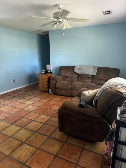 tiled living room with ceiling fan