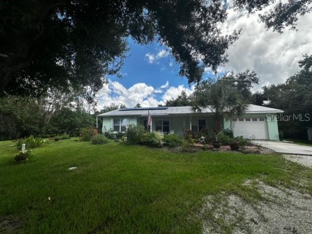 single story home featuring a garage and a front lawn