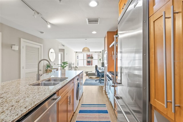 1120 E Kennedy Blvd Unit 734, Tampa, FL 33602 - kitchen featuring light stone counters, brown cabinets, stainless steel appliances, visible vents, and a sink