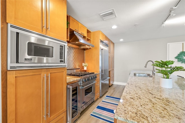 1120 E Kennedy Blvd Unit 734, Tampa, FL 33602 - kitchen with light wood finished floors, visible vents, a sink, built in appliances, and under cabinet range hood