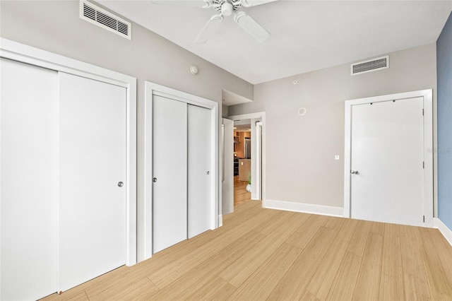 1120 E Kennedy Blvd Unit 734, Tampa, FL 33602 - unfurnished bedroom with light wood-type flooring, baseboards, visible vents, and multiple closets
