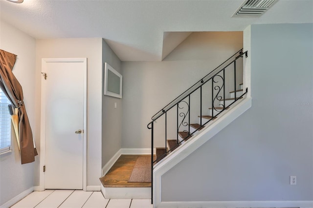 foyer entrance with a textured ceiling and light hardwood / wood-style floors